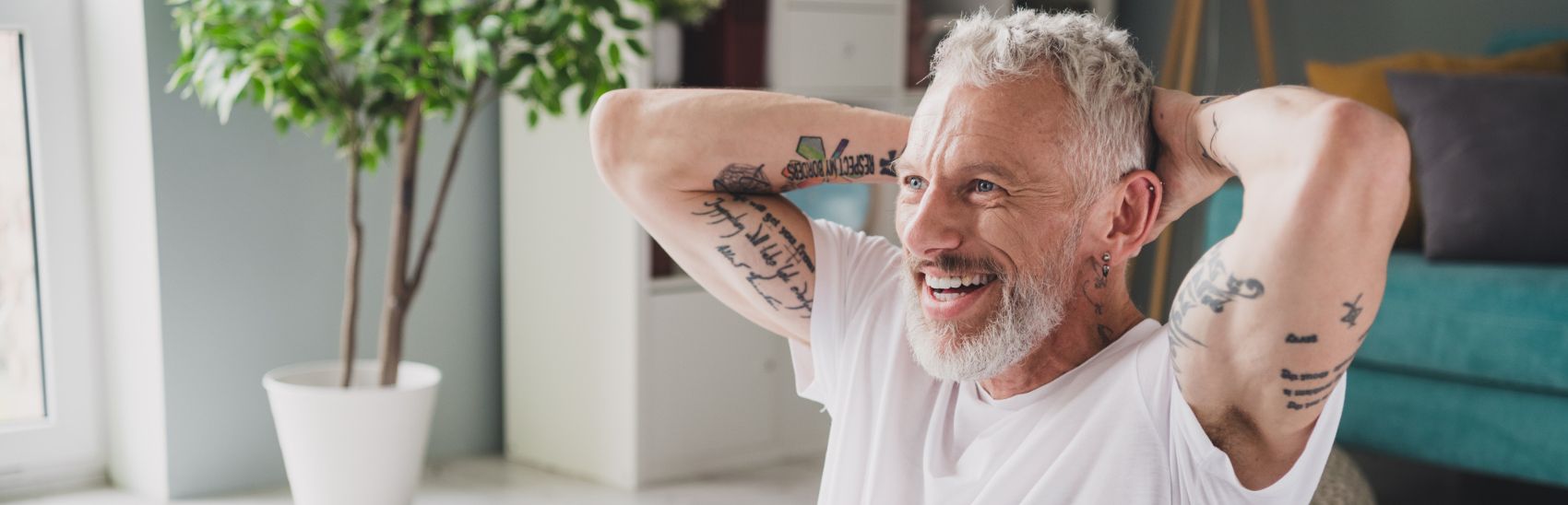A man with tattoos smiling with relief.