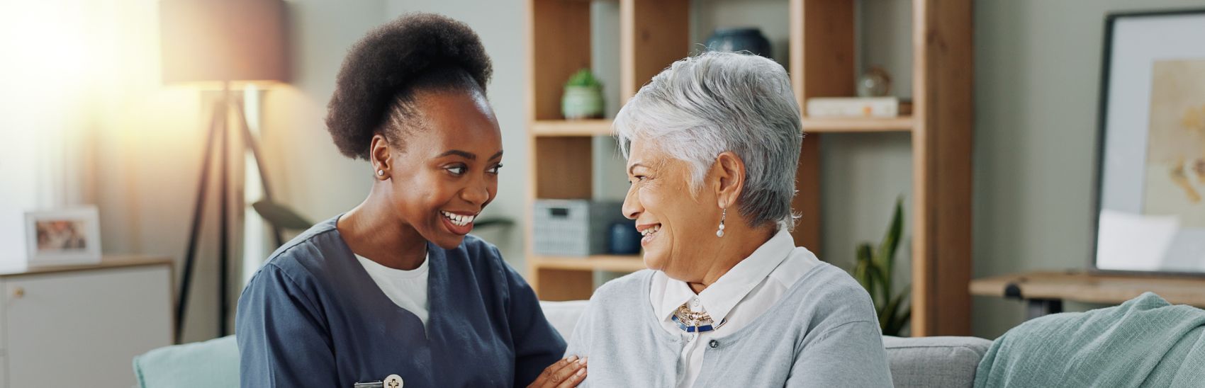 A nurse and her patient are smiling together.