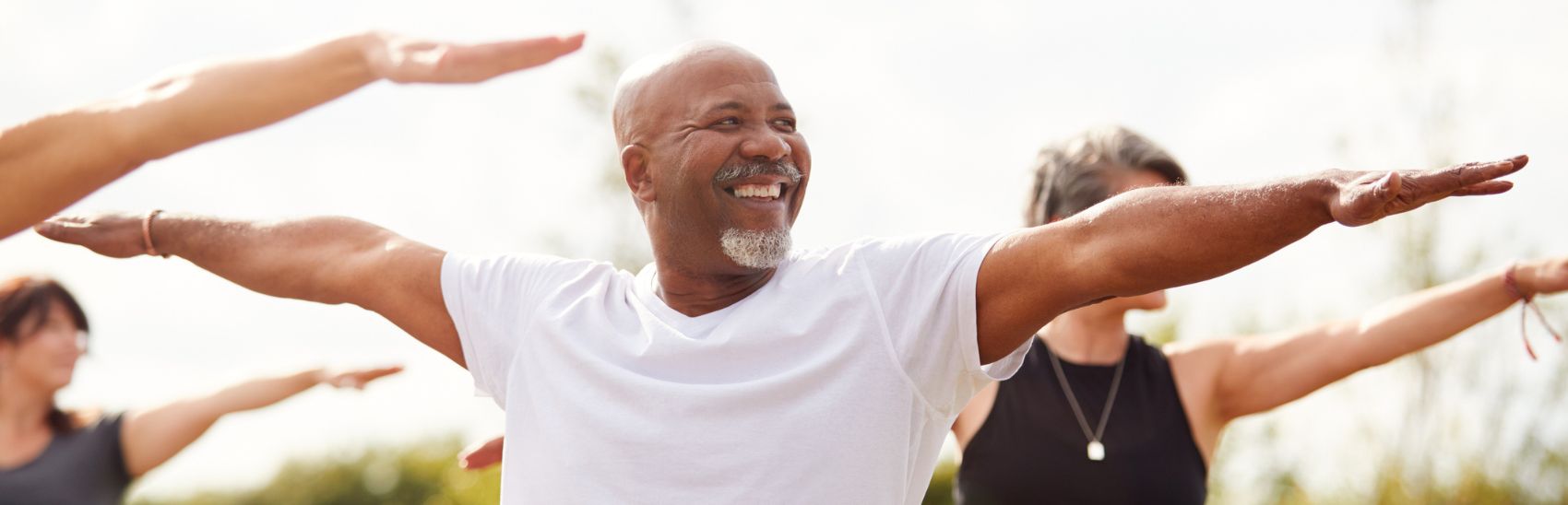 A man doing yoga outside for pain prevention.