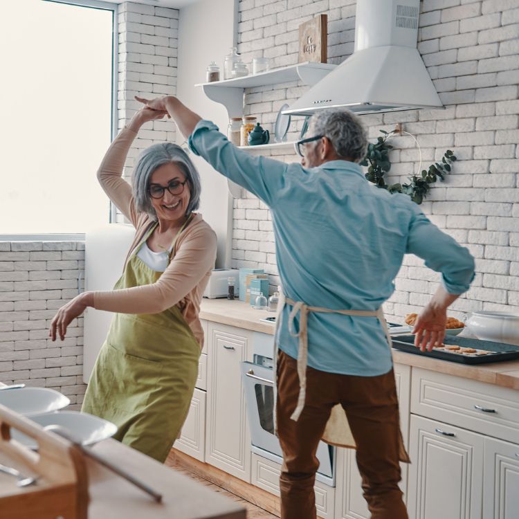 A couple dancing in their kitchen.
