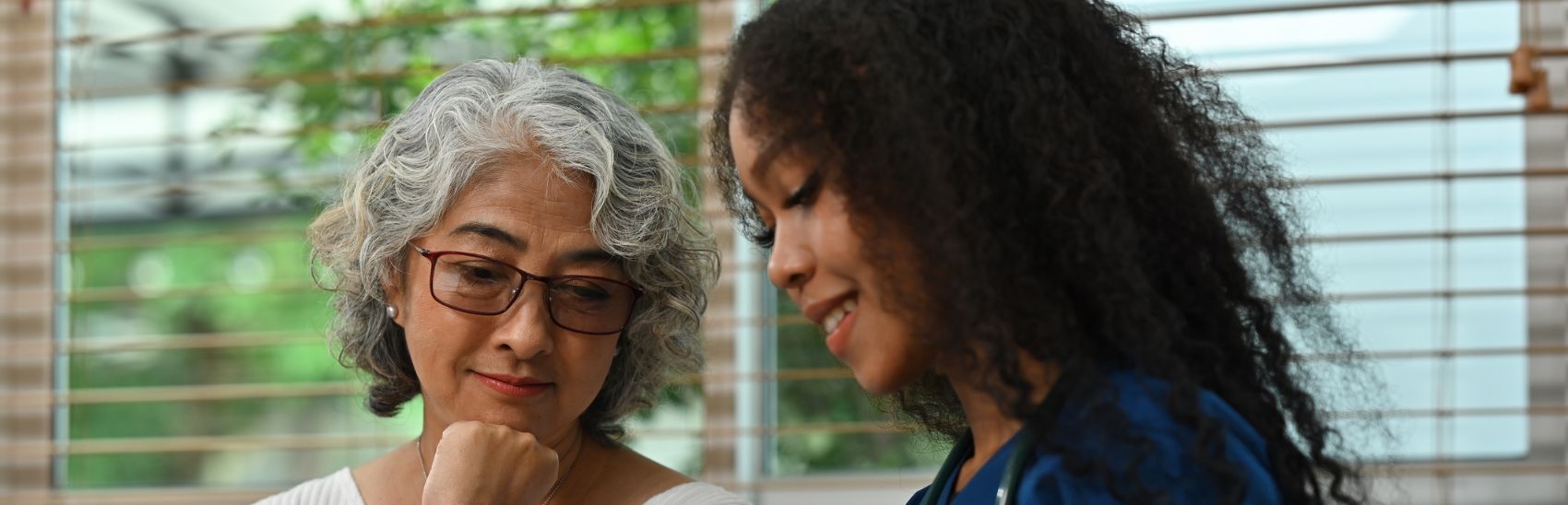 A lady and nurse looking through their pain management notes.